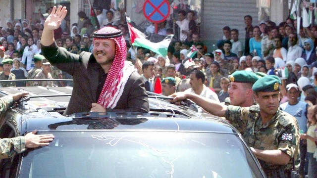 Jordanian King Abdullah II waves to crowds in Madaba during celebrations for the sixth anniversary of his coronation.