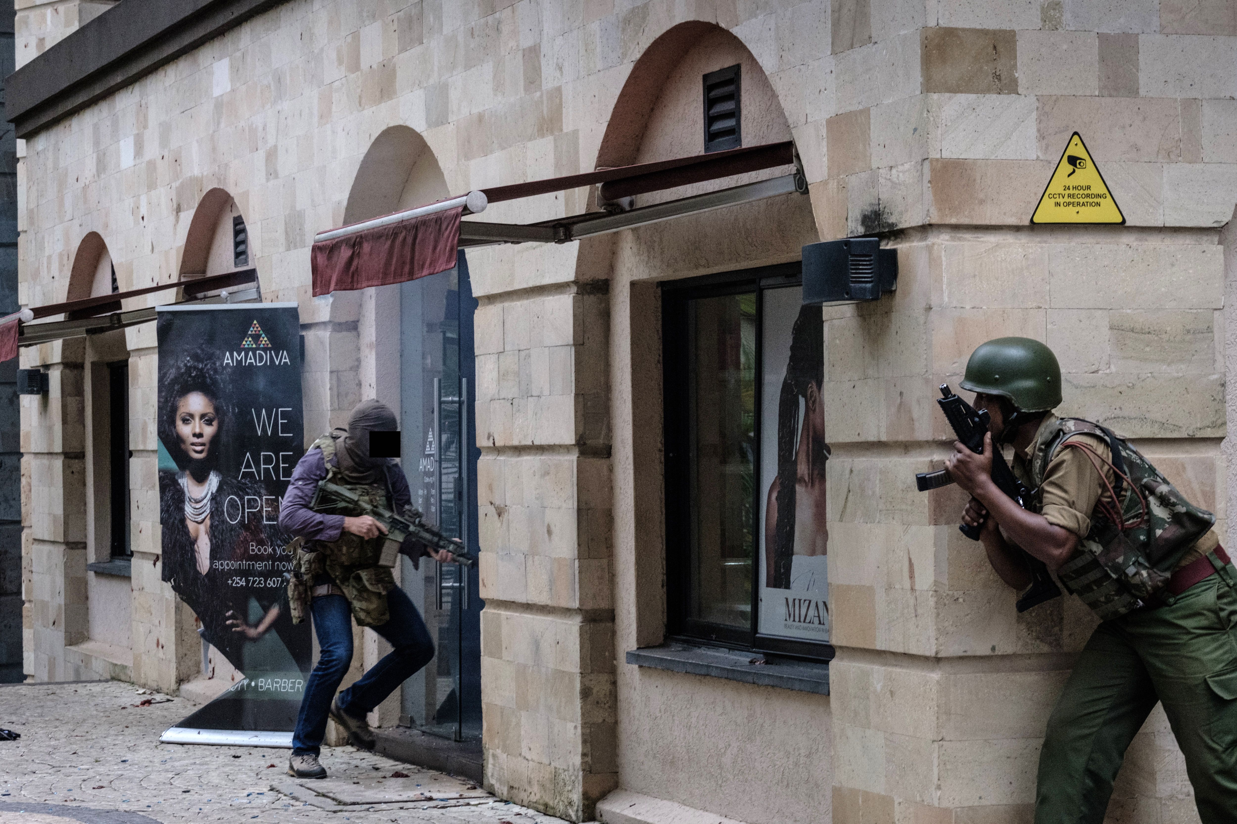 A member of Britain's Special Air Service Regiment (L) assists with the clearance of the Dusit hotel in Nairobi after al Shabaab militants stormed the hotel and office complex on Jan. 15.