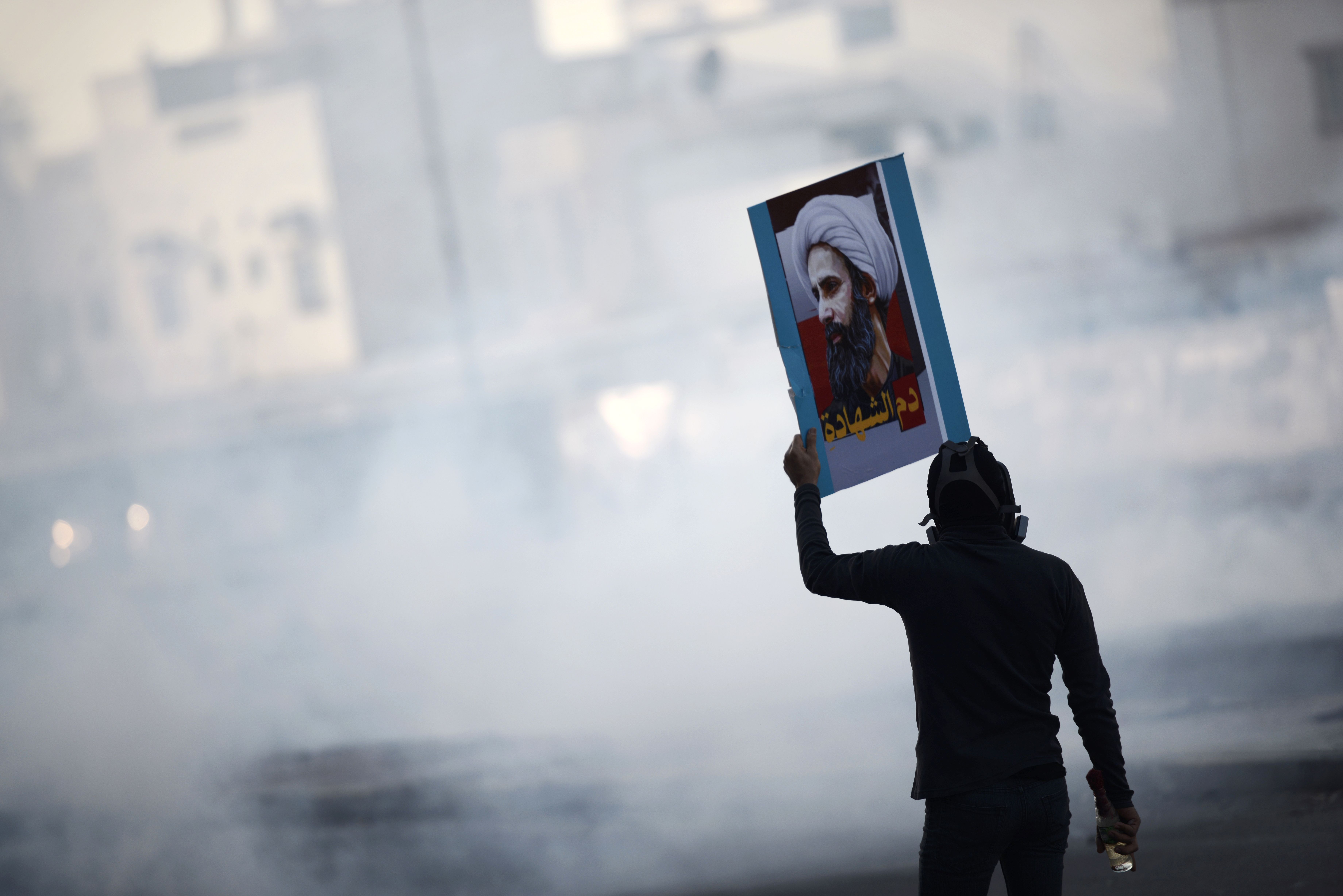 A Bahraini protester wields a portrait of Shiite Muslim cleric Nimr al-Nimr on Jan. 8, 2016, in the village of Sitra, south of the capital Manama.