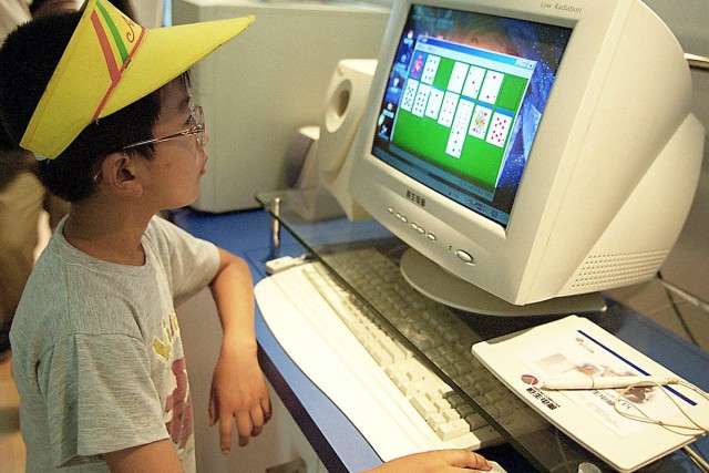 A child plays a game on a personal computer at a Beijing fair in July 2000. 