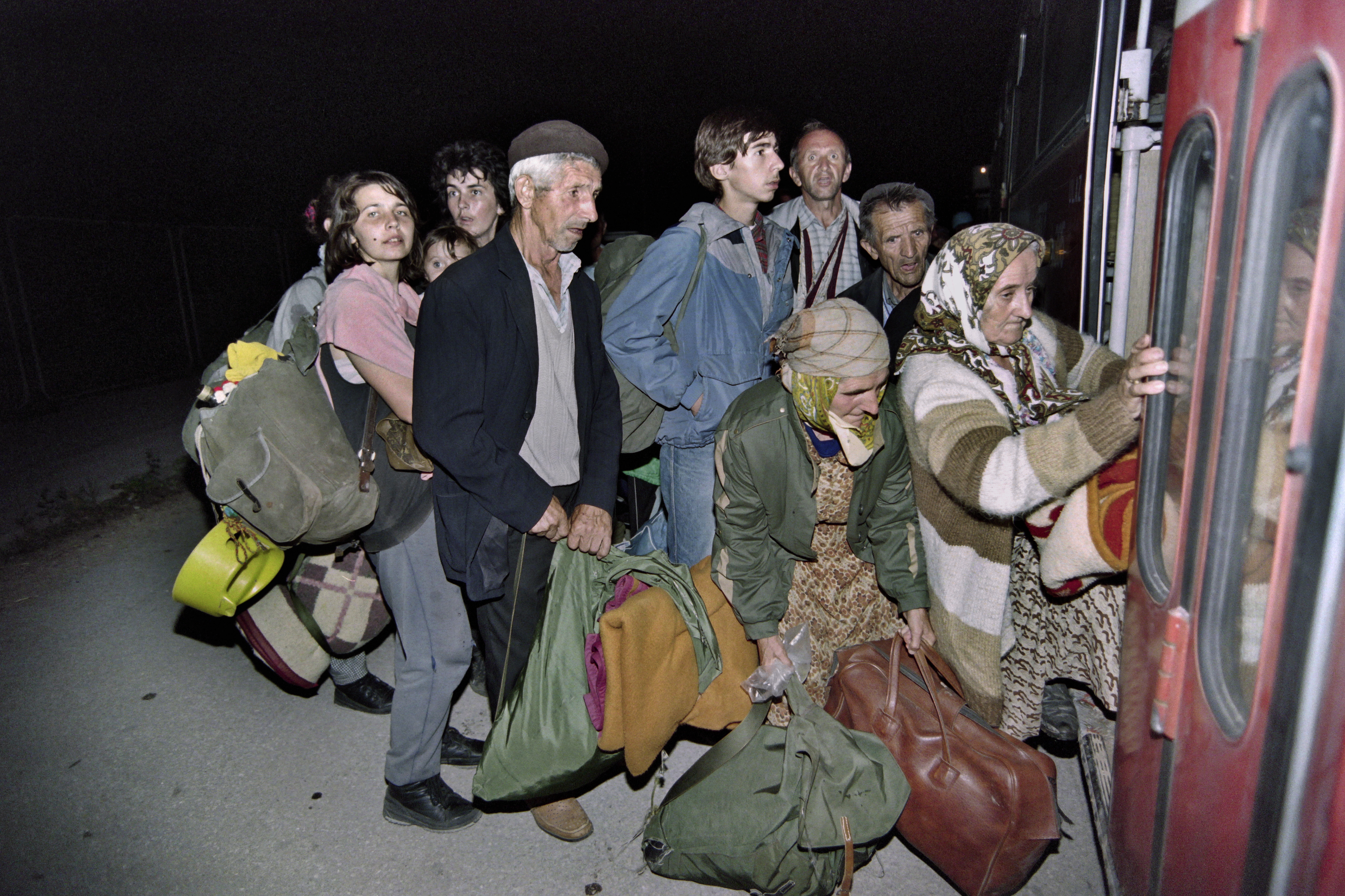 Elderly men, women, children and wounded evacuees flee the fallen enclave of Zepa, escorted by Bosnian Serbs, July 26, 1995.