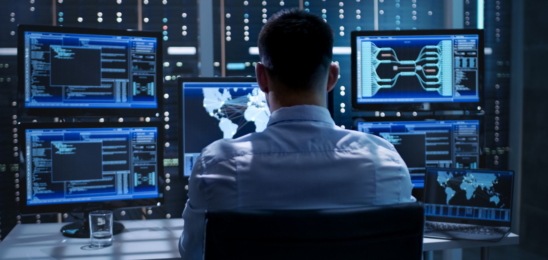 A man monitors computer screens.