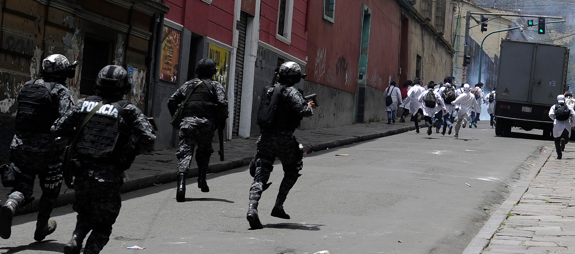 Riot police in La Paz chase medical students, who were protesting changes to Bolivia's malpractice laws.
