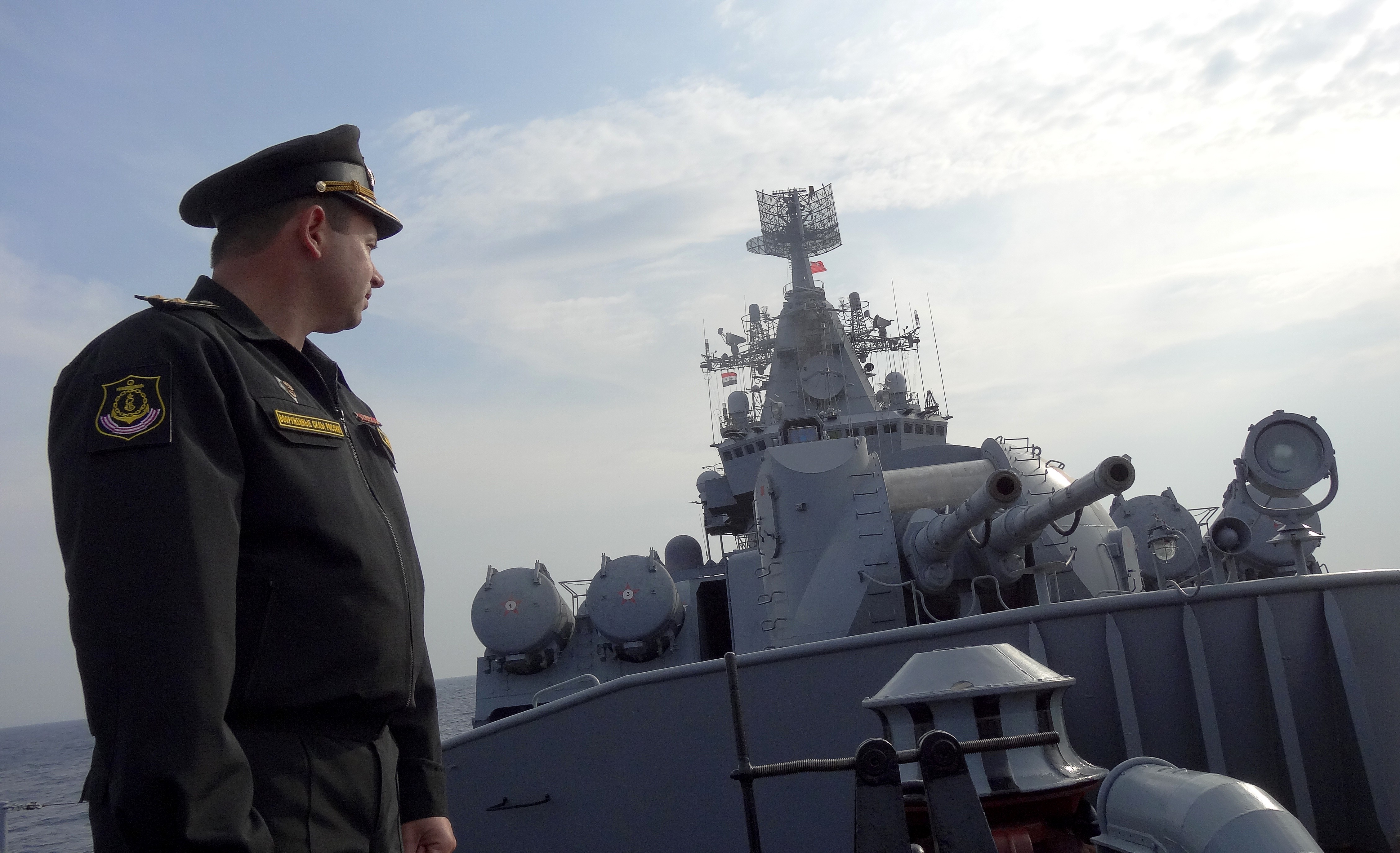 A Russian navy captain stands in front of an artillery system on the missile cruiser Moskva, on patrol in the Mediterranean Sea, off the coast of Syria on Dec. 17, 2015.