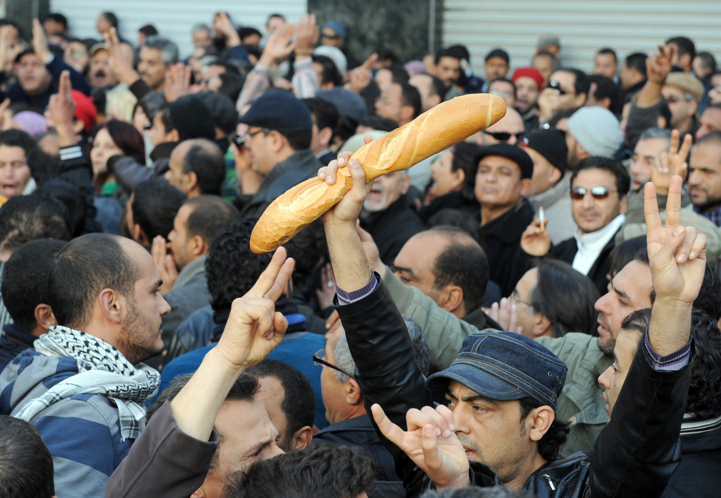 Protesters, one holding bread, shout slogans to show their solidarity with the residents of the Tunisian city of Sidi Bouzid during a demonstration on Dec. 27, 2010 in Tunis. 