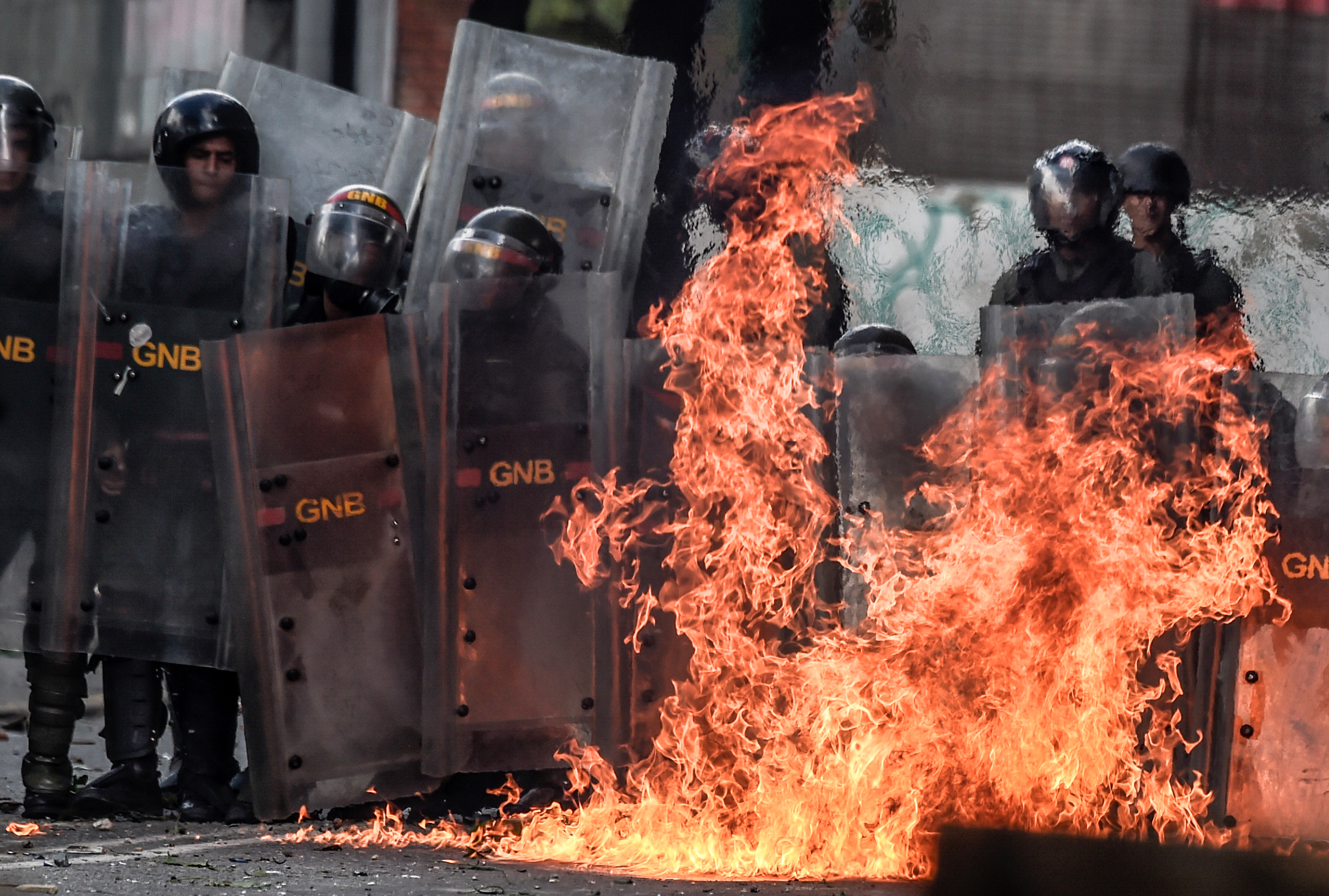 A Molotov cocktail thrown by anti-government activists explodes near members of the National Guard during clashes in Caracas on July 26. 