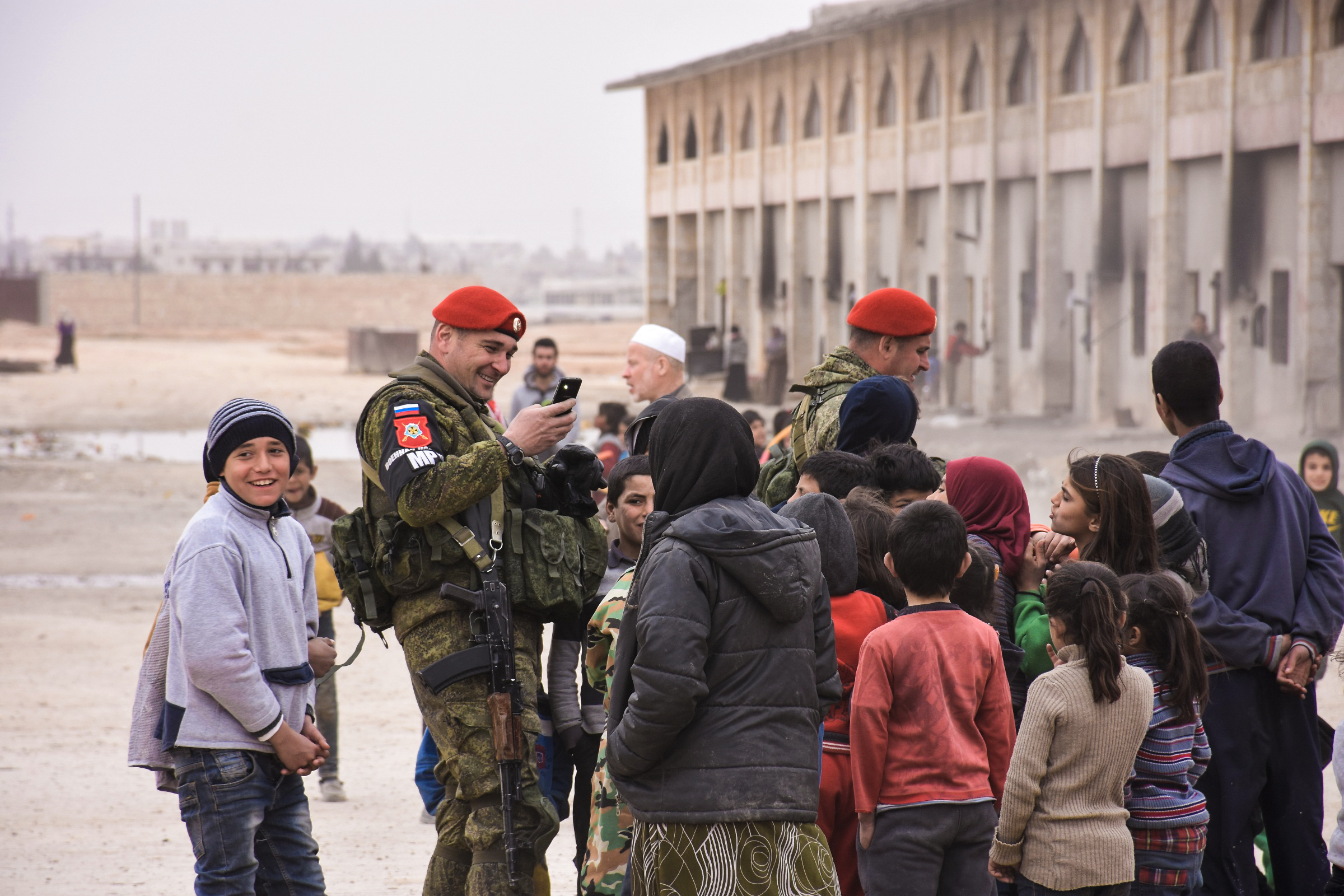 Members of the Russian military police take pictures with displaced Syrian children at a pediatric field hospital in a camp in Jibreen, on the outskirts of Aleppo.