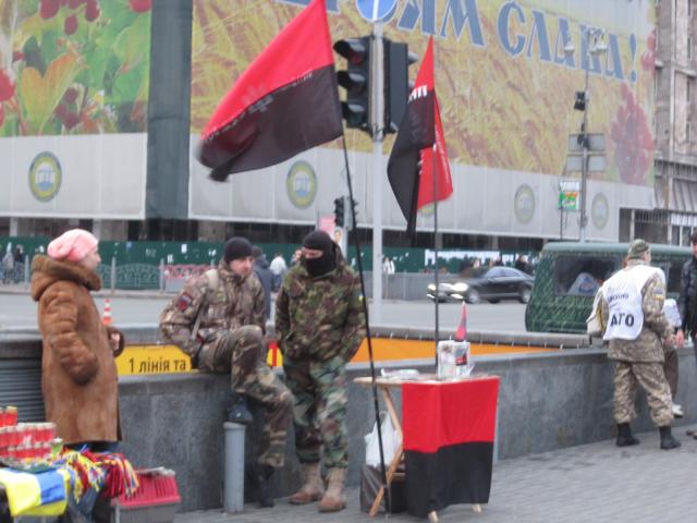 Members of Right Sector stand behind a table set up in Maidan Square next to representatives from the Aidar volunteer battalion collecting money for their group. 