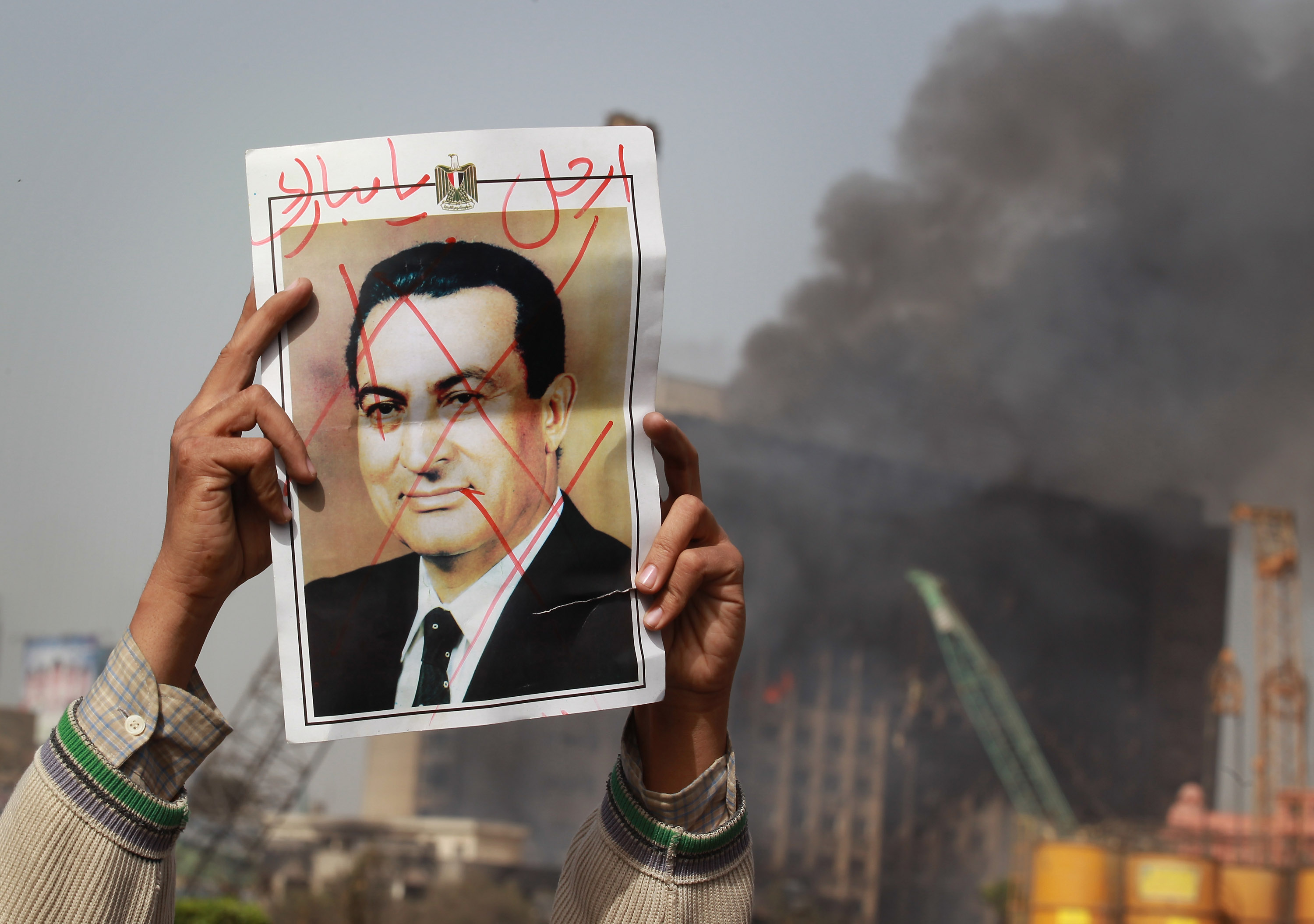 A protester in Tahrir Square holds a photo showing former Egyptian President Hosni Mubarak's face crossed out on Jan. 29, 2011 in Cairo, Egypt during the Egyptian Revolution.