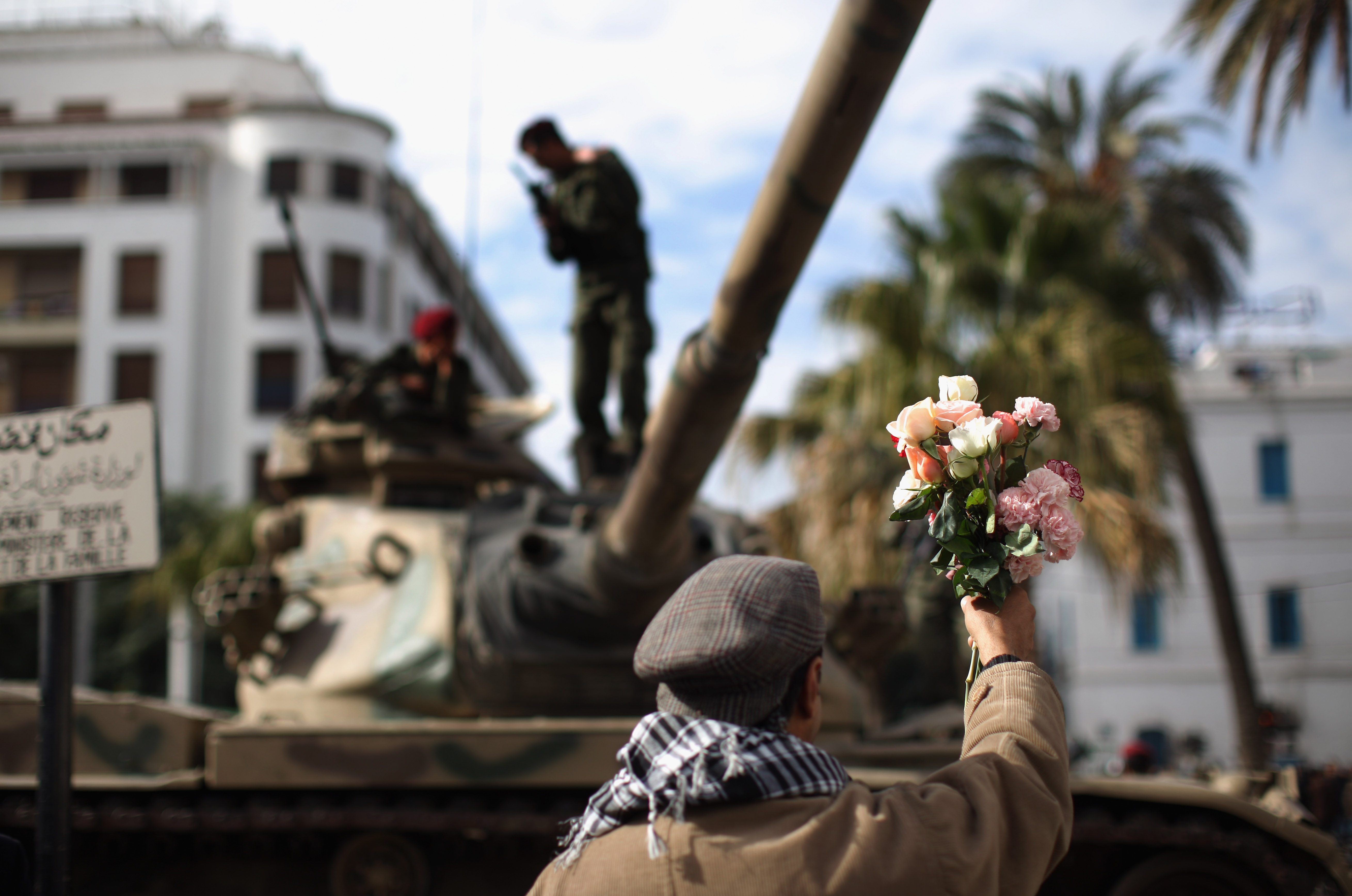 A protester offers flowers to soldiers on Jan. 21, 2011 in Tunis during a three-day period of mourning for the people who died during the country's revolution.