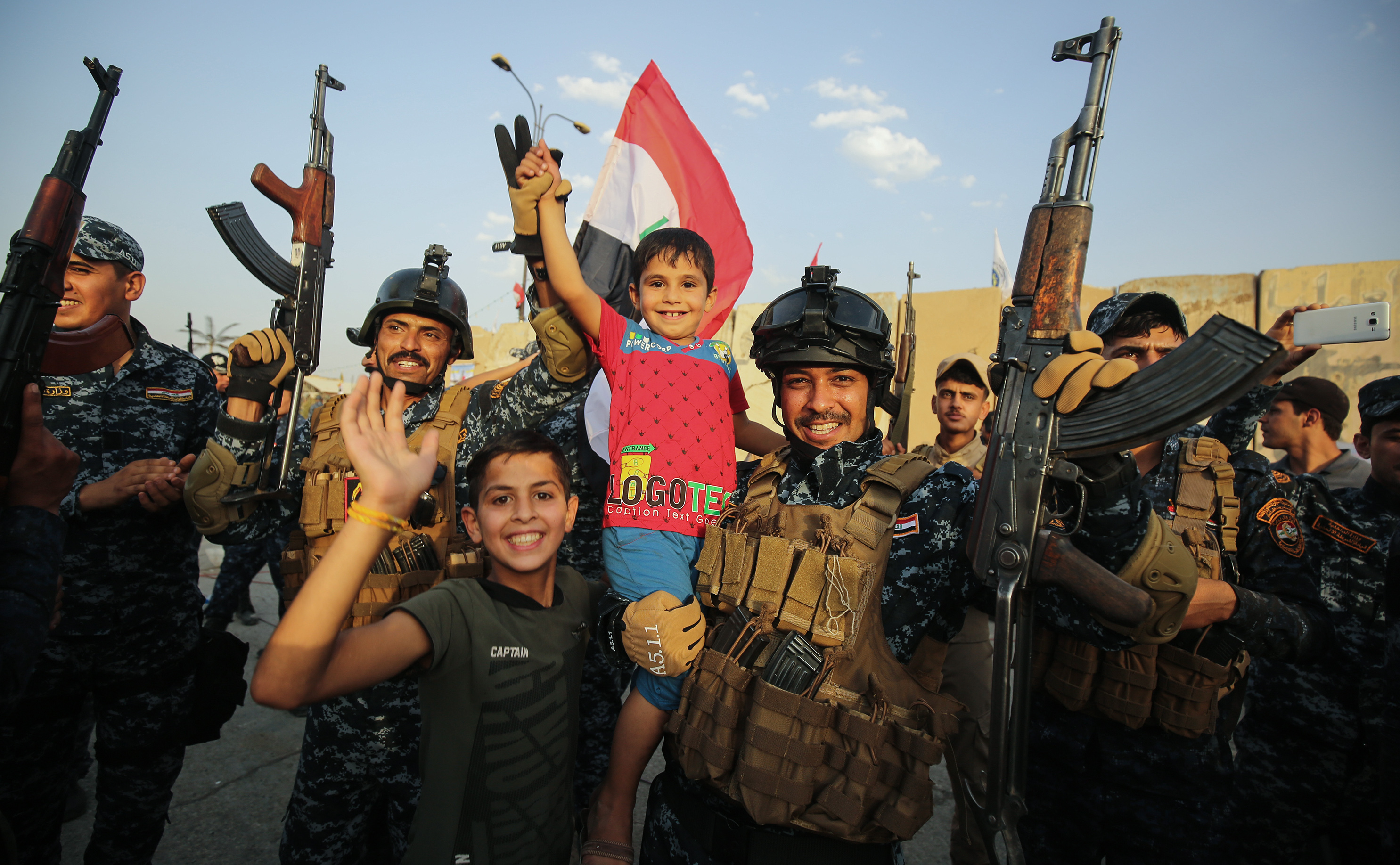 Members of the Iraqi federal police pose for a picture with children during a celebration in the Old City of Mosul during the closing stages of the grueling battle to retake Iraq's second city from Islamic State, July 2.