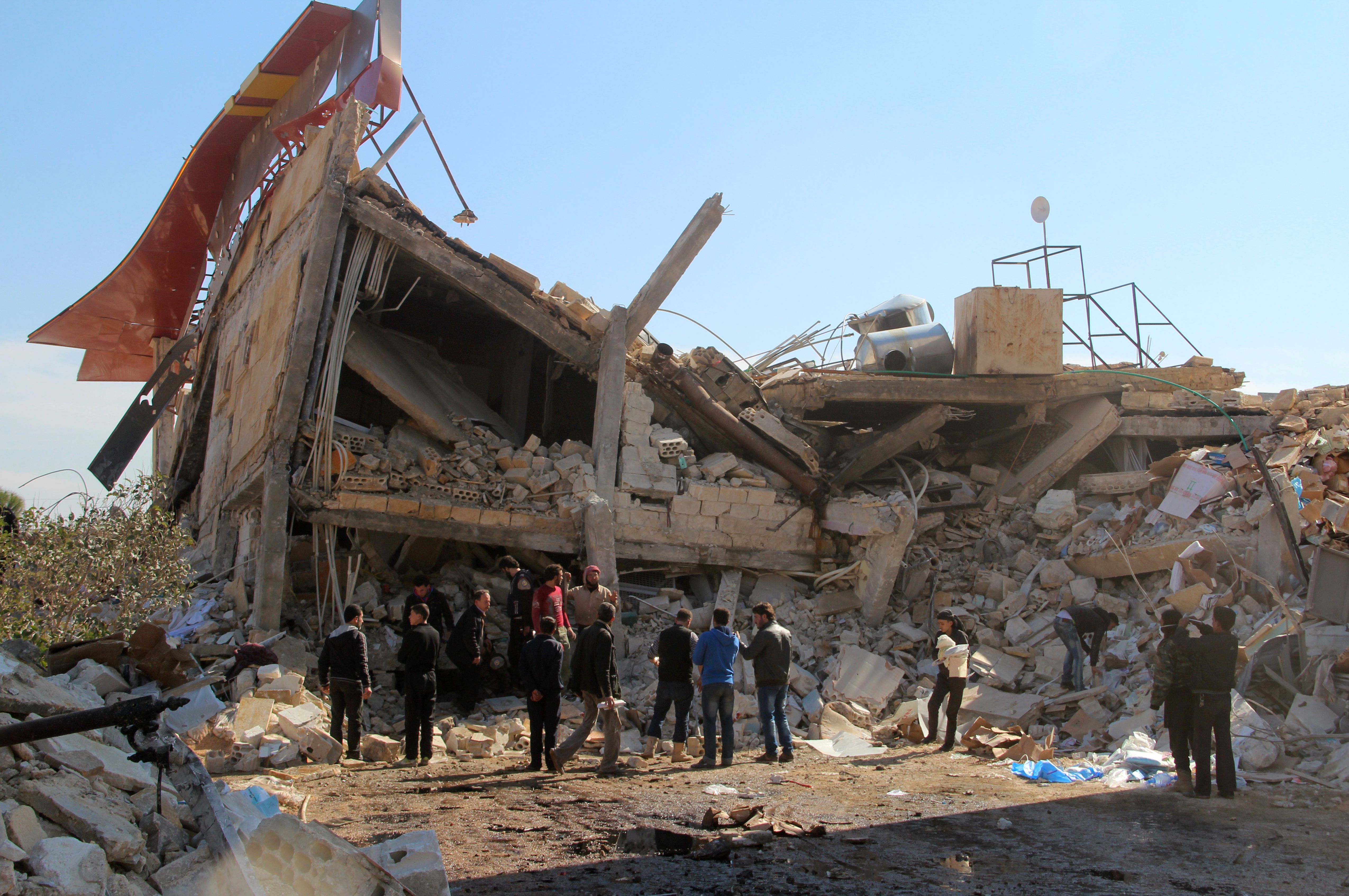 Syrians gather around the rubble of a hospital supported by Doctors Without Borders near Maarat al-Nuaman, in the northern province of Idlib.