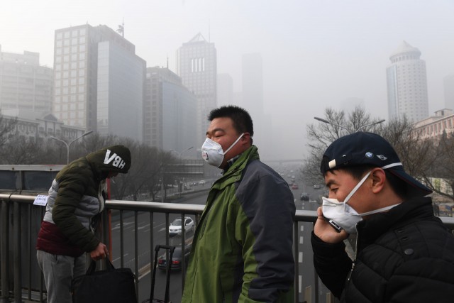 Pedestrians in Beijing brave the smog with the help of masks. During the winter, many cities in northeast China are enveloped in dense smog as residents burn coal and other fuel for heat.