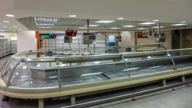 Bare shelves greet shoppers at one Caracas grocery store. 