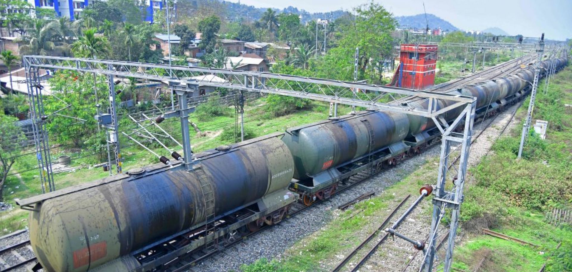 An oil tanker train passes near a refinery in Guwahati, India, on March 30, 2023.