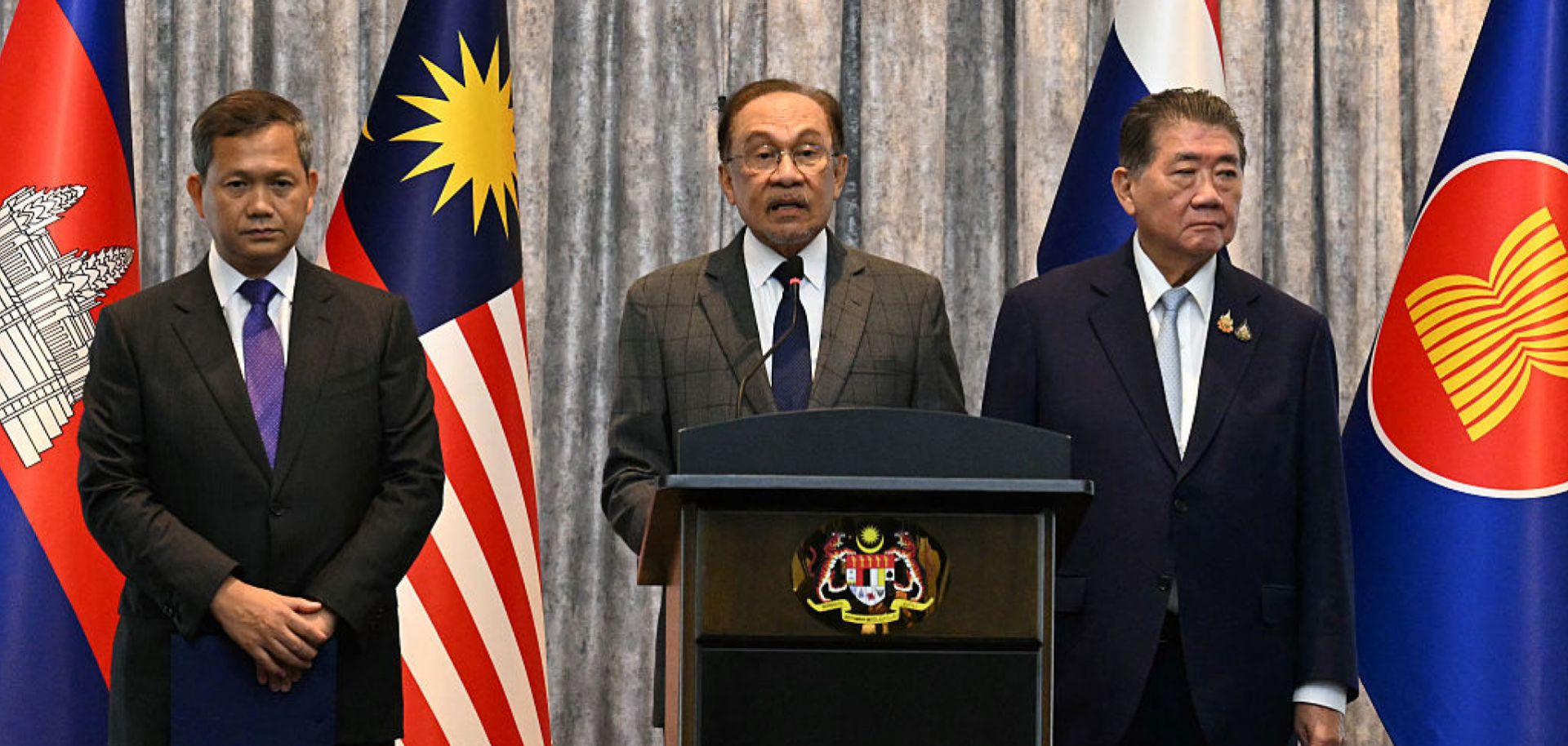 Malaysian Prime Minister Anwar Ibrahim (center) speaks during a press conference next to Cambodian Prime Minister Hun Manet (left) and Thailand's acting prime minister Phumtham Wechayachai (right) in Putrajaya, Malaysia, on July 28, 2025.