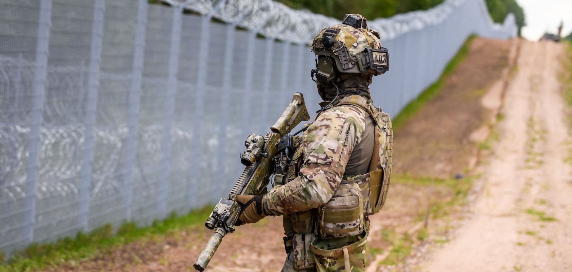 A Latvian border guard patrols along the fence at the Belarusian border near Krivanda, eastern Latvia, on Aug. 8, 2023.