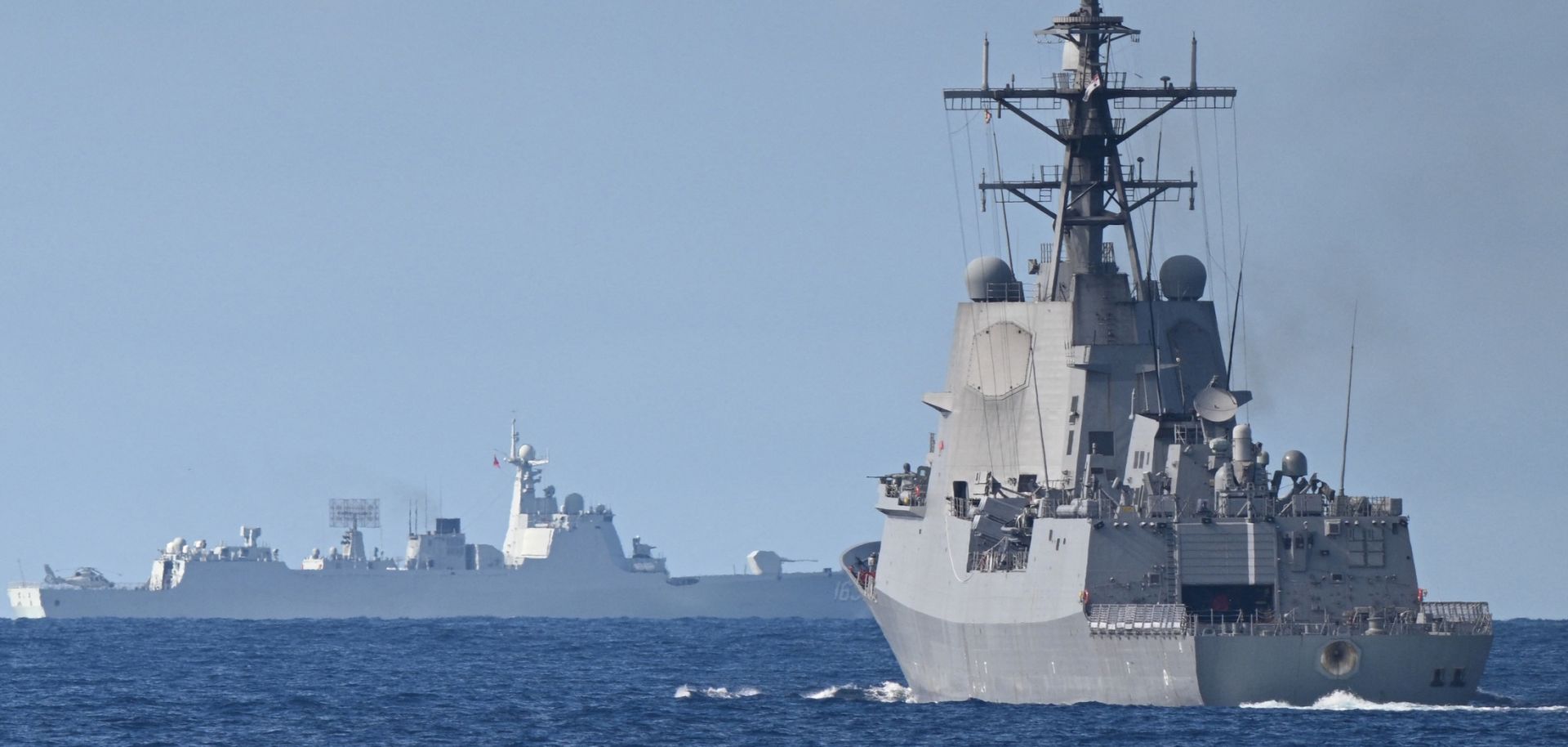 A Chinese navy ship (background left) is seen while an Australian navy ship (right) takes part in a maritime cooperative activity with the Philippines and Canada in the disputed waters of the South China Sea on Sept. 3, 2025.