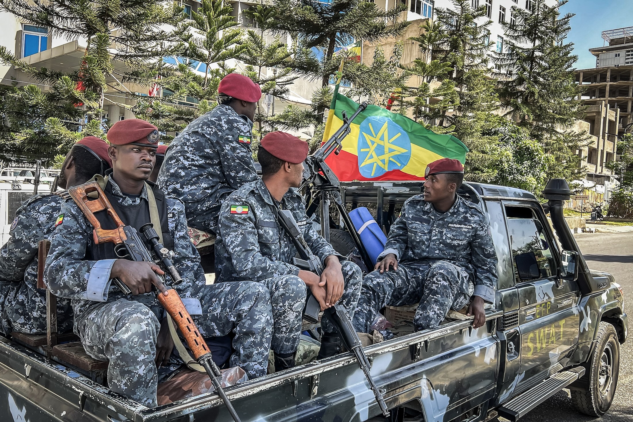 Ethiopian police patrol aboard a pickup truck as they resume operations after federal forces pushed back the rebel Tigray People