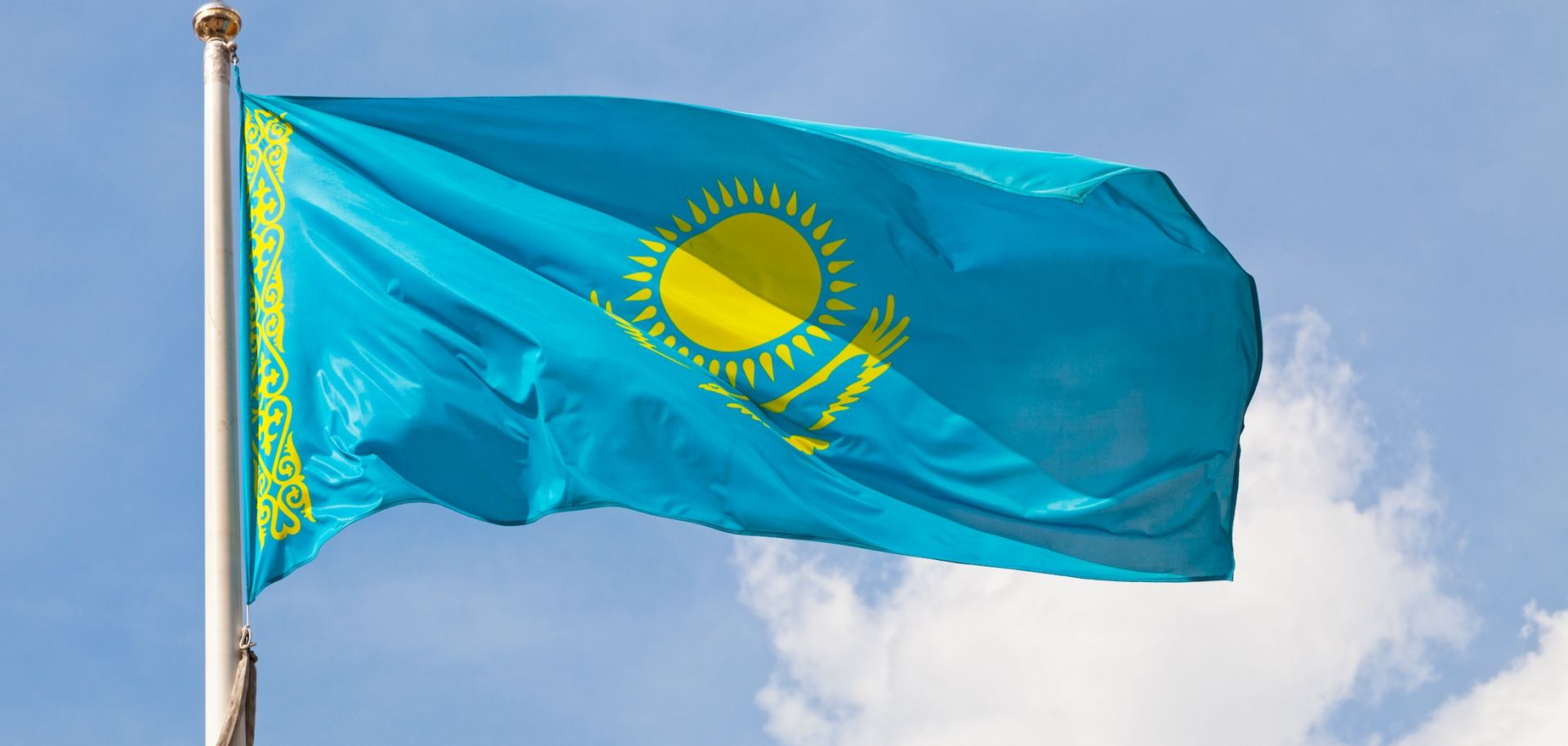 The national flag of Kazakhstan waves in the wind.