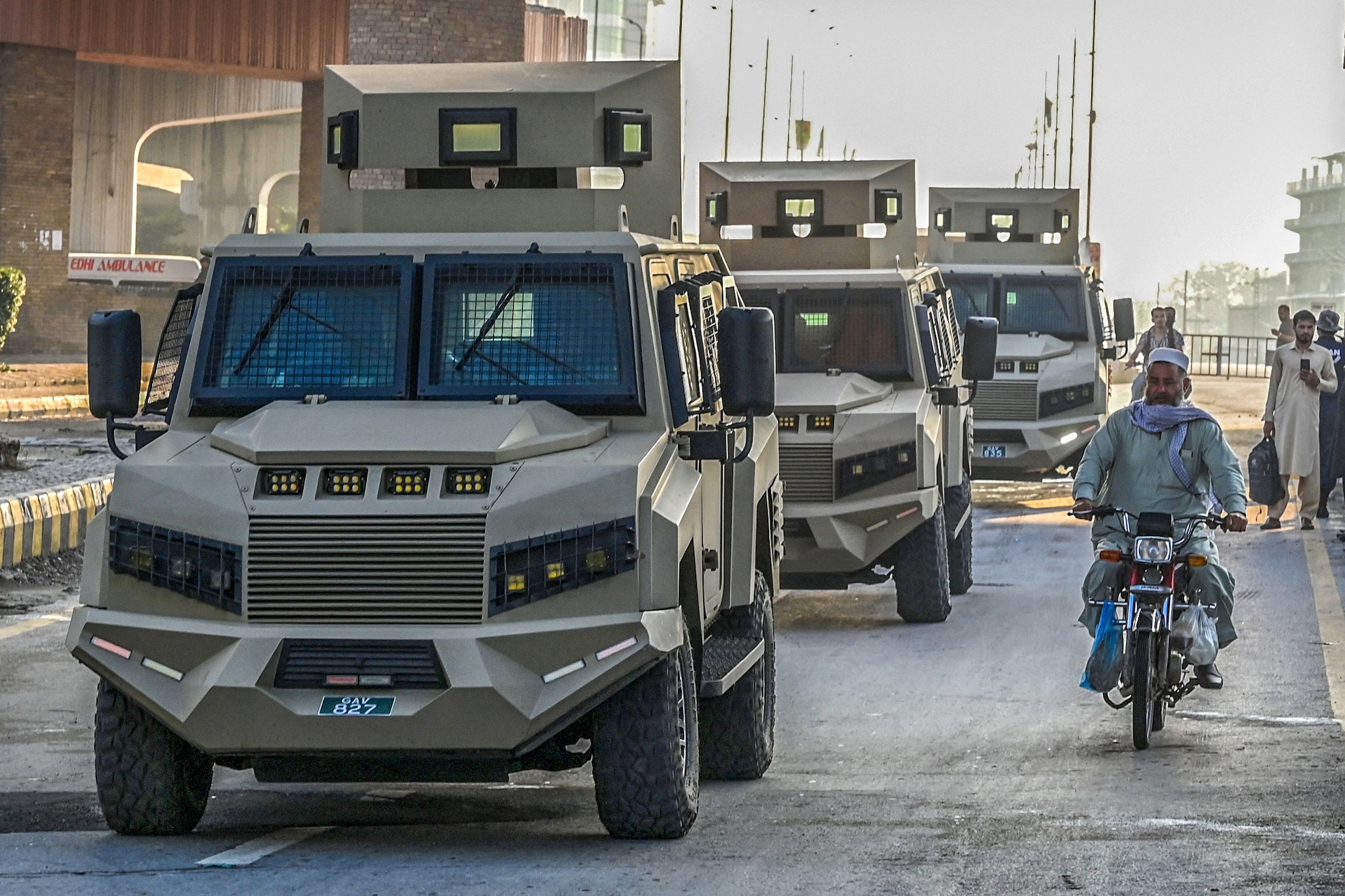 Armored police vehicles drive along a road in Peshawar, Pakistan, on Oct. 12, 2026, following the imposition of emergency rule in the province.